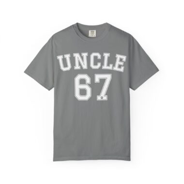 Unk 67 Shirt laid flat, dark grey vintage wash cotton with white varsity lettering.